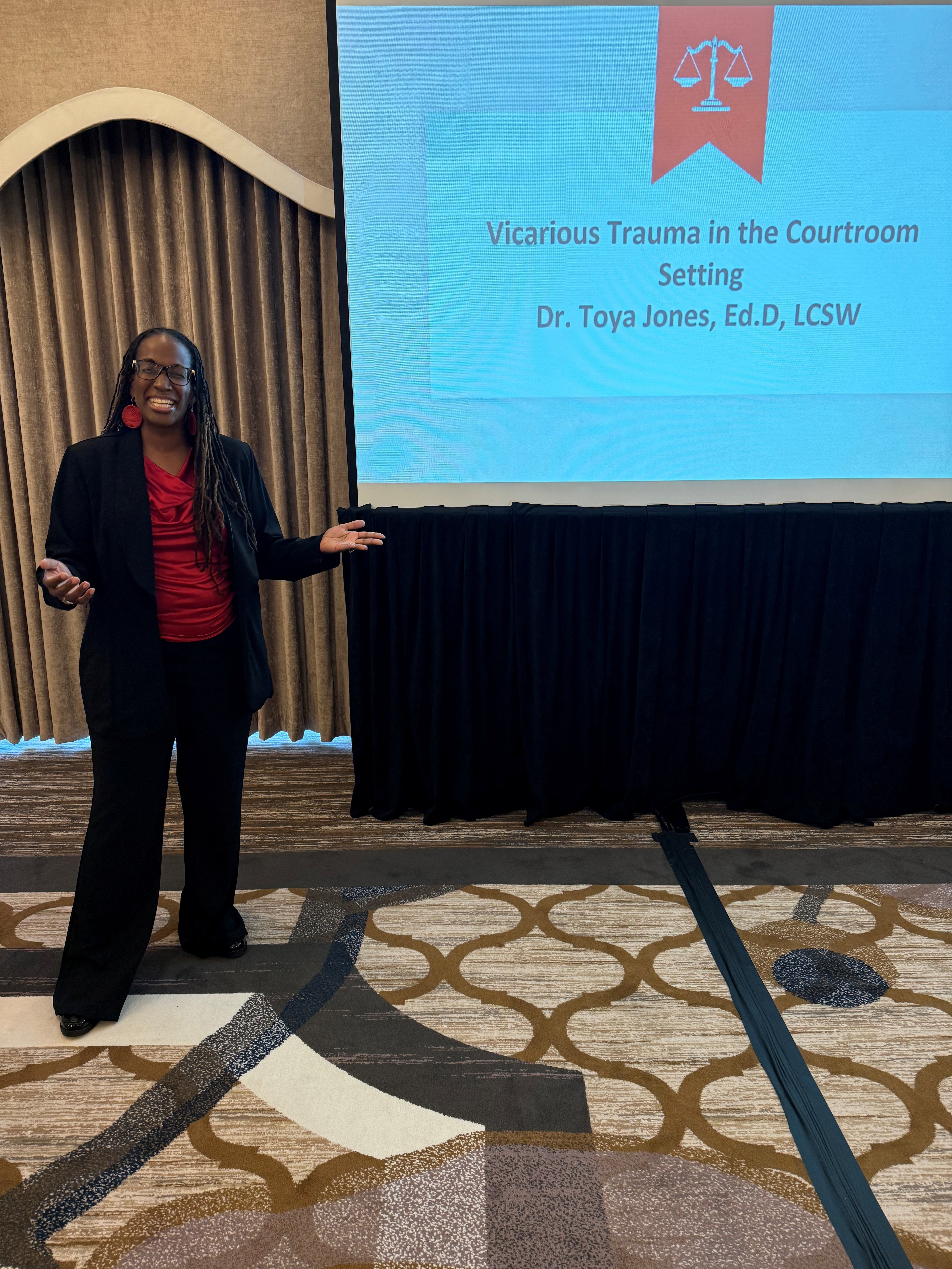 Dr. Toya Jones standing in front of a presentation screen