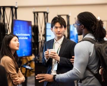 Faculty and students talking at a research conference