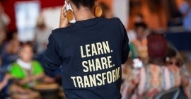 Student with t-shirt that reads "Learn. Share. Transform."