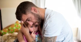 Father comforts little girl