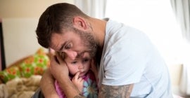 Father comforts little girl
